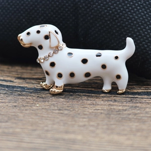 Macro shot of enamel spotted dog brooch featuring a gold rhinestone collar and details