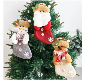 Detailed view of Santa, Snowman, and Reindeer stockings hanging on a Christmas tree