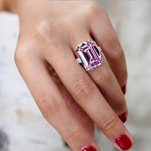Luxury emerald-cut pink zircon ring with rectangular side stones on a model's hand