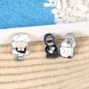 Detail of three creative enamel pins depicting traditional cartoon wrestler characters