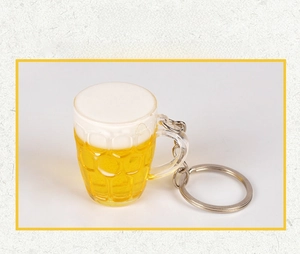 Makroaufnahme vom 3D-Acryl-Bierkrug-Schlüsselanhänger mit Schaum und gelber Flüssigkeit