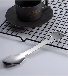 Close-up of stainless steel 5-in-1 camping utensil on mesh rack with coffee cup