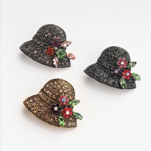 Macro shot of three vintage straw hat brooches with rhinestones and enamel flower details