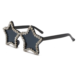 Detail view of star-shaped sunglasses with shimmering rhinestones and black lenses