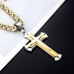 Close-up of gold and silver two-tone cross pendant with heavy Byzantine chain link