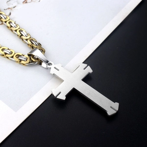 Two-tone woven chain necklace with silver cross pendant on a black and white background