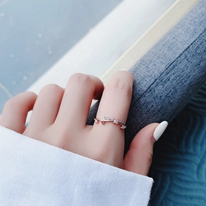 Detail of rose gold vine ring with pink and purple zircons worn on model finger