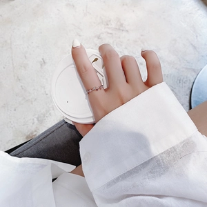 Close-up of rose gold floral ring with sparkling zircon stones on a model's hand