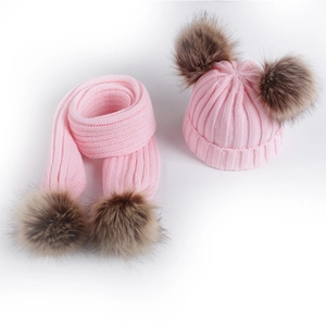Pink winter knit set for babies featuring a warm hat and scarf with faux fur pom-poms