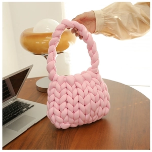 Close-up of pink chunky knit handbag featuring soft thick woven texture and handle