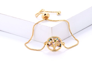 Detailopname van een gouden levensboom armband met levendige gekleurde zirkonia stenen