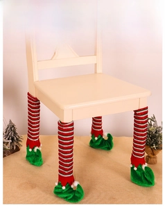 Detail of red striped Christmas elf chair leg covers with green elf shoes and pom poms