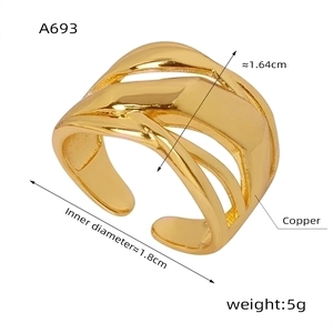 Macro detail of gold-tone cross-woven open ring with 1.64cm width and copper texture