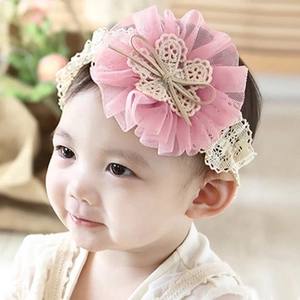 Detailed shot of pink mesh flower and white lace bow headband on a baby girl model