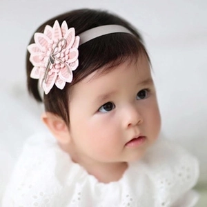 Close-up of baby girl wearing pink fabric flower headband with elastic gray band