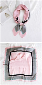 Detailed view of square silk scarf with geometric color blocks in pink and grey