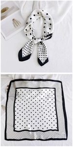 Close-up of a silk square scarf with classic black and white polka dot pattern design