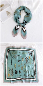 Detail view of mint green silk square scarf with classic equestrian horse bit patterns
