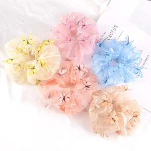 Five pastel mesh scrunchies with 3D butterfly patches in soft colors on white background