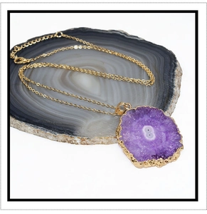 Dettaglio della collana con ciondolo a girasole in agata druzy viola e bordo dorato