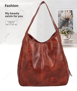 Close-up of brown hobo bag showing retro cracked leather texture and brand logo detail