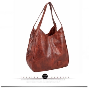 Macro shot of vintage brown leather texture and logo patch on the large tote bag