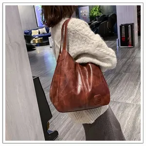 Detailed macro view of retro brown pebble leather texture on a large slouchy tote bag