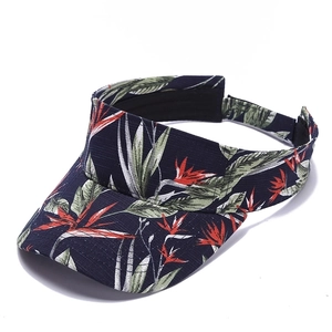 Macro detail of navy blue tropical floral print on a breathable cotton visor cap