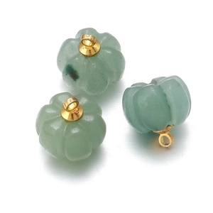 Macro detail of three green aventurine quartz pumpkin pendants with gold loops