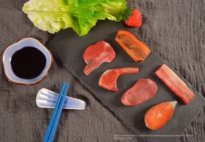 Vue détaillée de pendentifs en PVC imitation viande réaliste sur un plateau en pierre noire