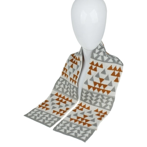 Détail d'une écharpe en maille à motifs triangles géométriques blanc gris et caramel