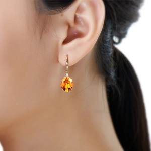 Oval yellow crystal drop earrings in gold plating shown on model for elegant styling