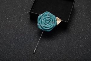 Detailed teal fabric rose lapel pin with gold leaf detail and silver long needle