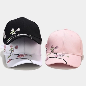 Detail of floral peach blossom embroidery on cotton baseball caps in black white and pink