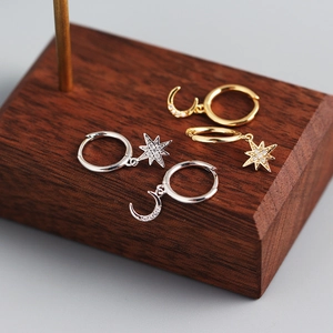 Macro shot of S925 sterling silver star and moon asymmetrical earrings with zircon