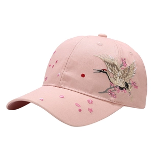 Pink cotton baseball cap featuring crane and cherry blossom embroidery on a white background