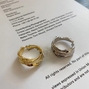 Detail showing irregular molten texture and metallic ripples on gold and silver rings