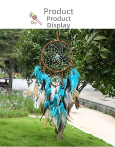 Detail of bohemian tree of life dreamcatcher with blue feathers hanging on a tree branch