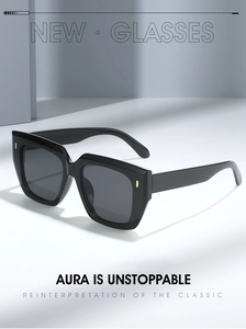 Detailed close-up of large square black sunglasses featuring elegant gold metal rivets