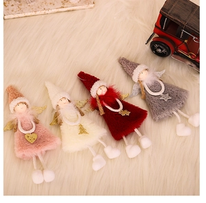 Close-up of plush angel ornaments with feather wings and knit hats on white rug