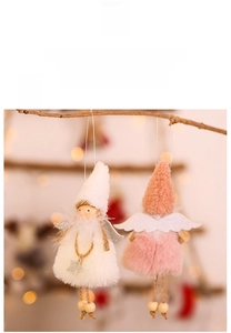 Close-up of plush Christmas angel dolls with silver wings and knit hats in festive setting