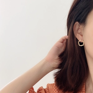 Irregular textured gold 925 silver stud earrings on a female model with a white background