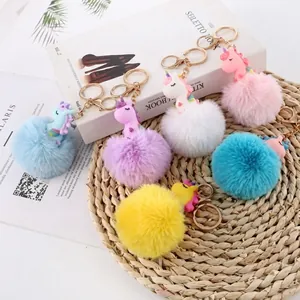 Flachbild von bunten Einhorn-Kunstpelz-Pompon-Schlüsselanhängern in Blau und Rosa