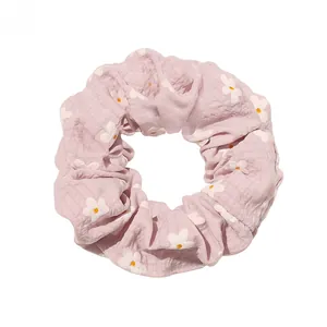 Close-up of lavender plaid scrunchie with daisy print and ruffled seersucker texture