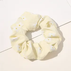 Detail of yellow plaid scrunchie with small daisy print and textured fabric