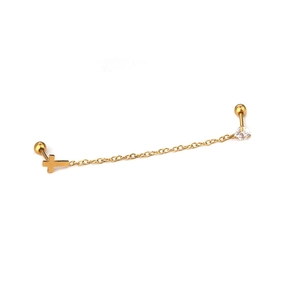 Macro detail of gold chain earring with cross pendant and clear zircon stud connector