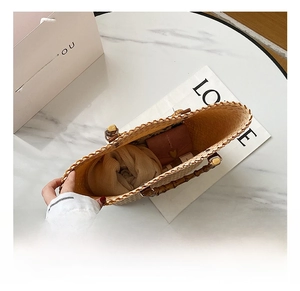 Détail de l'intérieur spacieux du sac cabas en paille avec poignées en bambou