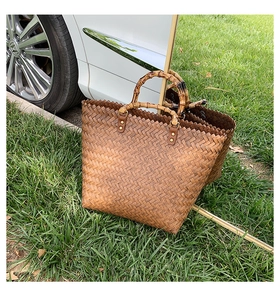 Détail d'un sac cabas marron tissé à la main avec poignées en bambou et fixations à rivets