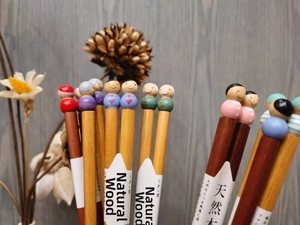 Detailed view of Japanese wooden chopsticks featuring cute colorful doll head toppers