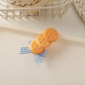 Detailed view of handmade biscuit hair clips with blue gingham ribbon bows